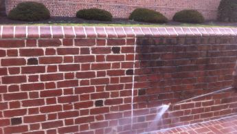 Commercial pressure washing being performed on brick wall